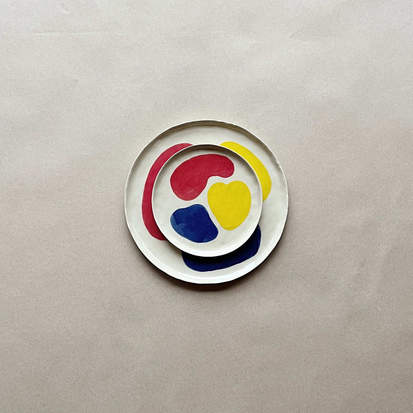 handmade ceramic tricolor dessert plate on top of tricolor dinner plate