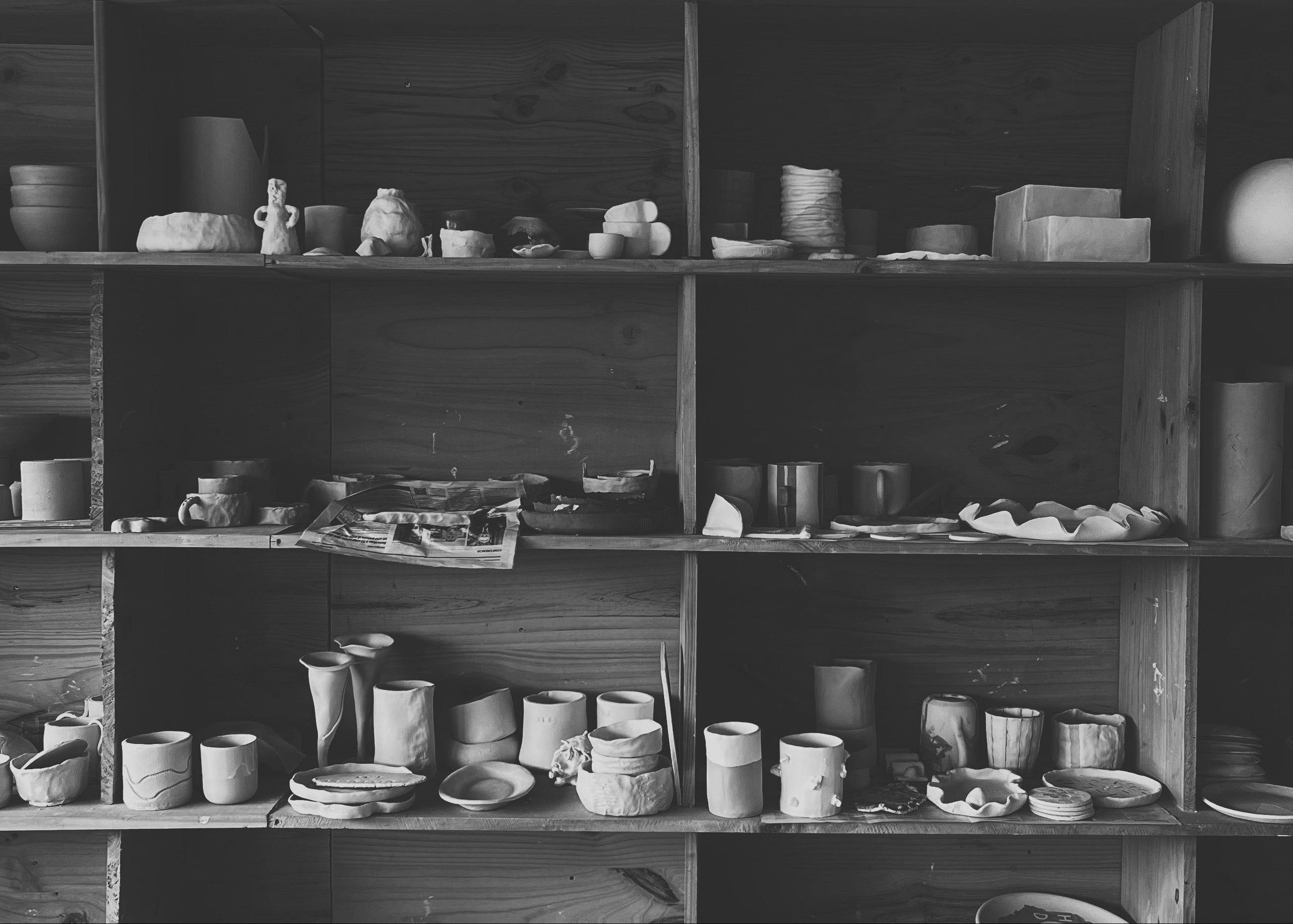 Shelves filled with various ceramic items in a workshop setting
